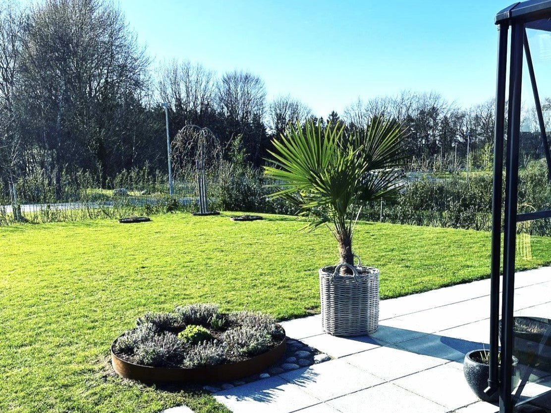 Runde Beetumrandung aus Cortenstahl im Terrassengarten – hochwertiger Pflanzring aus Metall