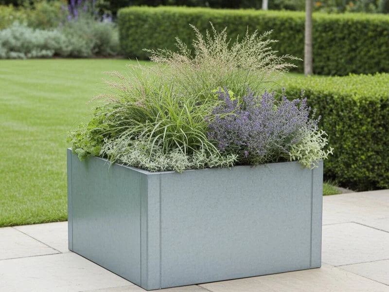 CUBY quadratischer Pflanzkübel aus verzinktem Stahl mit Ziergräsern im Garten