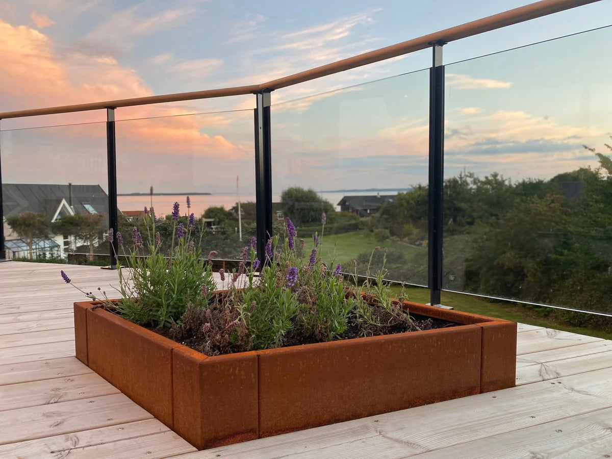 byJEMA Pflanzkübel aus Cortenstahl mit Lavendel auf Holzterrasse bei Sonnenuntergang