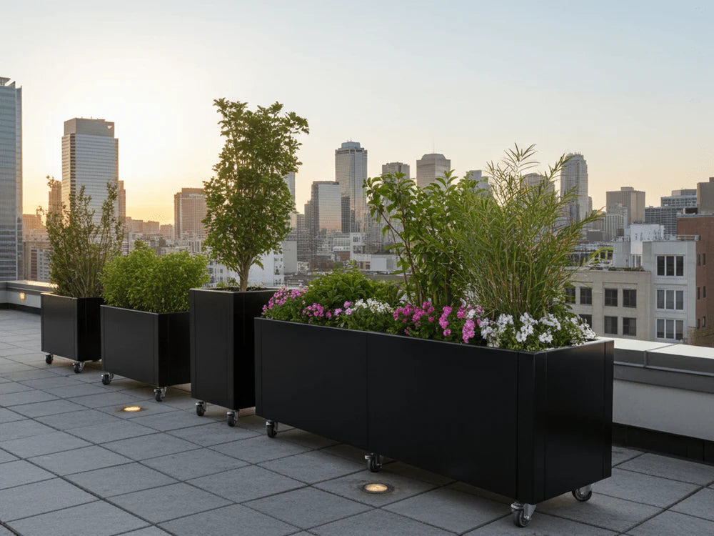 byJEMA CUBY Pflanzkübel aus schwarz pulverbeschichtetem Stahl mit Rollen auf moderner Dachterrasse