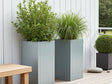 CUBY Pflanzkübel aus verzinktem Stahl auf moderner Terrasse mit grünen Pflanzen