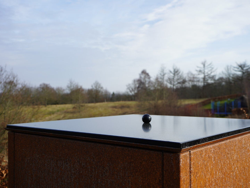 Deckel aus schwarz lackiertem Stahl mit glänzender Oberfläche im Tageslicht