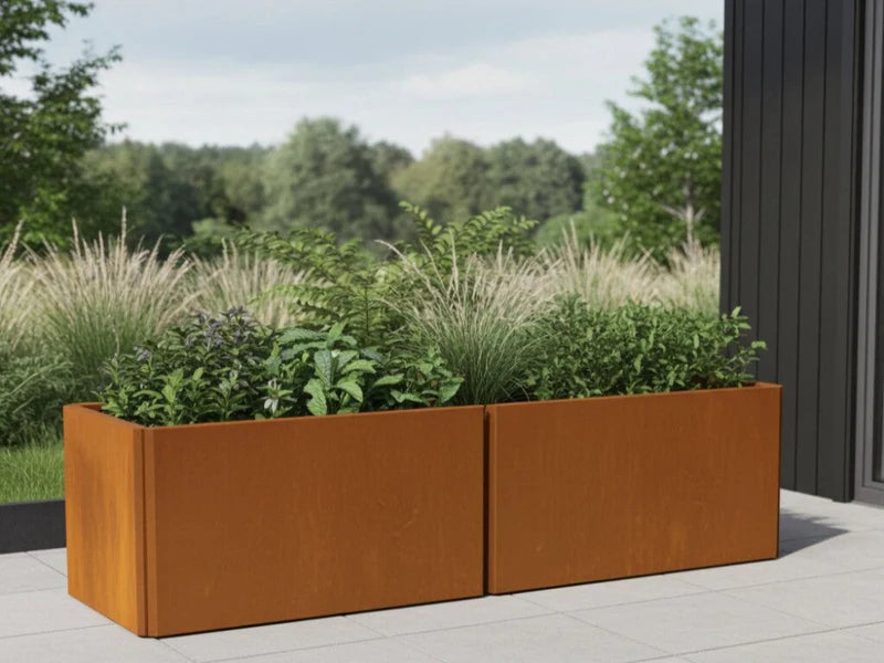 EDGY Pflanzkübel aus Cortenstahl mit Gräsern auf Terrasse an moderner Fassade