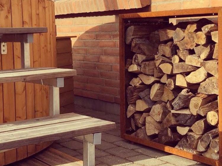 Robustes Holzlager aus Cortenstahl im Außenbereich neben Terrasse