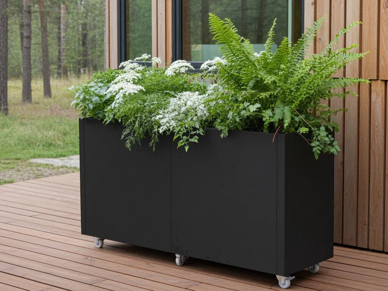Pflanzkasten aus schwarzem Stahl auf Rollen mit üppiger Bepflanzung