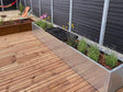 Langer Pflanzkübel aus verzinktem Stahl entlang einer Holzterrasse