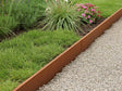 Rasenkante aus Cortenstahl zwischen Rasenfläche und Kiesweg