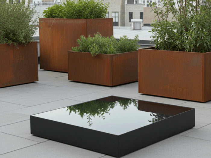 Quadratisches Wasserbecken aus schwarz lackiertem Stahl auf moderner Terrasse